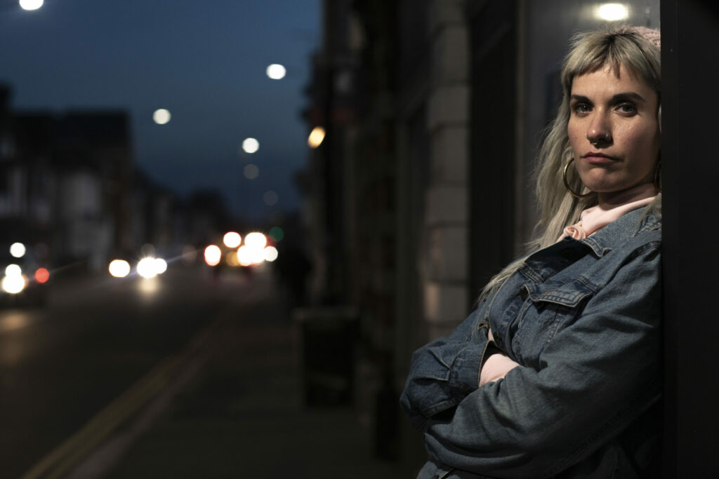 Woman standing in a doorway, representing addiction, isolation, and harm reduction in a disease awareness campaign for Ethypharm, delivered by EatMoreFruit Communications